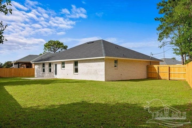 rear view of property featuring a yard