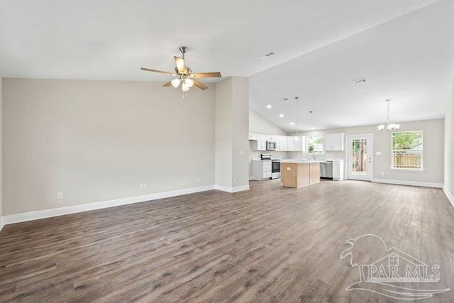 unfurnished living room featuring vaulted ceiling, ceiling fan with notable chandelier, and dark hardwood / wood-style floors