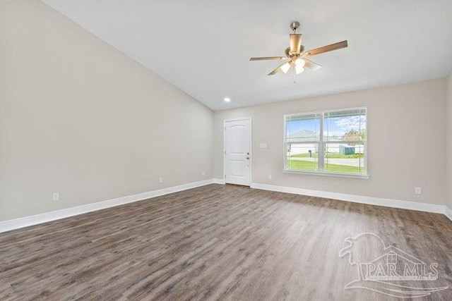 empty room with lofted ceiling, ceiling fan, and dark hardwood / wood-style floors