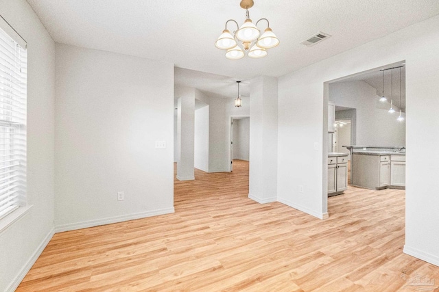 6240 Tributary St, Pensacola, FL 32526 - empty room featuring an inviting chandelier and light hardwood / wood-style floors