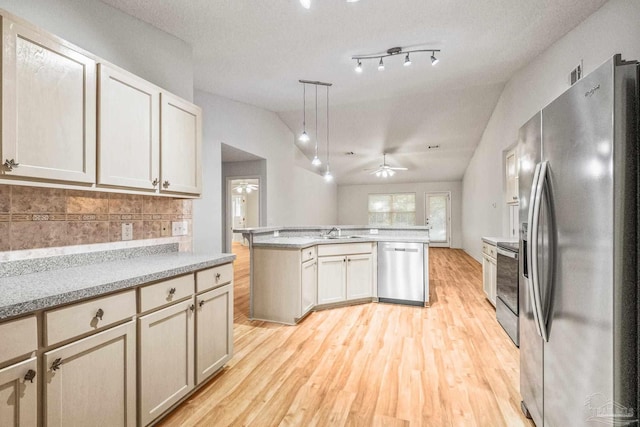 6240 Tributary St, Pensacola, FL 32526 - kitchen with decorative light fixtures, appliances with stainless steel finishes, a kitchen island, light hardwood / wood-style floors, and decorative backsplash