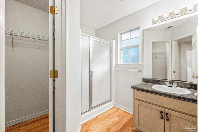6240 Tributary St, Pensacola, FL 32526 - bathroom with vanity, hardwood / wood-style floors, an enclosed shower, and a textured ceiling