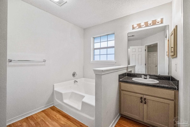 6240 Tributary St, Pensacola, FL 32526 - bathroom with a bathing tub, wood-type flooring, vanity, and a textured ceiling