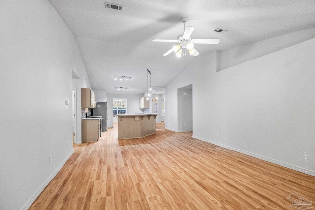 6240 Tributary St, Pensacola, FL 32526 - unfurnished living room featuring a textured ceiling, light hardwood / wood-style flooring, ceiling fan, and vaulted ceiling