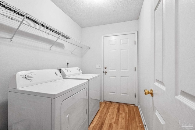 6240 Tributary St, Pensacola, FL 32526 - clothes washing area featuring a textured ceiling, independent washer and dryer, and light hardwood / wood-style floors