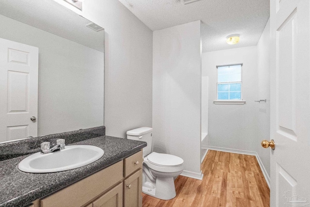 6240 Tributary St, Pensacola, FL 32526 - bathroom with vanity, hardwood / wood-style flooring, a textured ceiling, and toilet