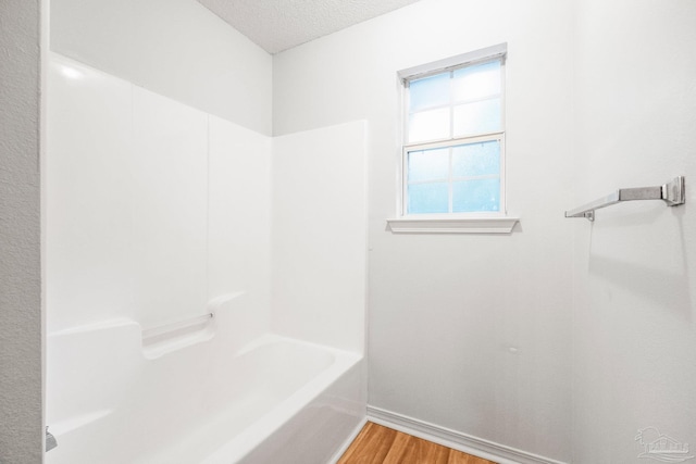 6240 Tributary St, Pensacola, FL 32526 - bathroom featuring wood-type flooring, bathing tub / shower combination, and a textured ceiling