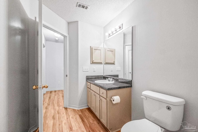 6240 Tributary St, Pensacola, FL 32526 - bathroom with hardwood / wood-style flooring, vanity, toilet, and a textured ceiling