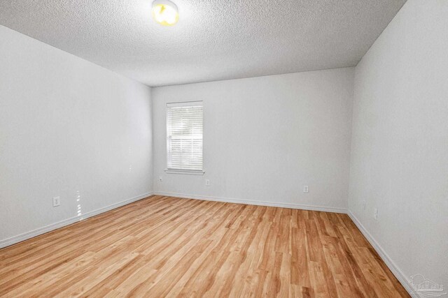 6240 Tributary St, Pensacola, FL 32526 - empty room with a textured ceiling and light hardwood / wood-style flooring