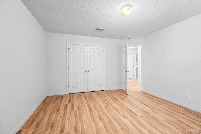 6240 Tributary St, Pensacola, FL 32526 - unfurnished bedroom featuring a closet, a textured ceiling, and light hardwood / wood-style flooring
