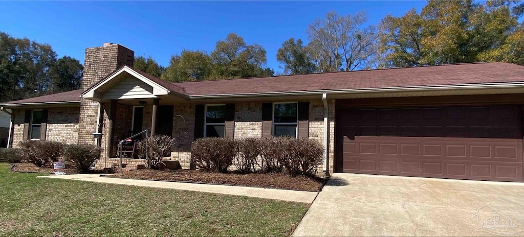 ranch-style home featuring driveway, a front yard, an attached garage, brick siding, and a chimney