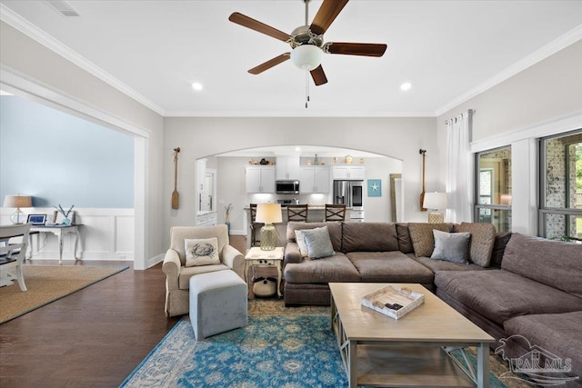1504 Cadence Loop, Cantonment, FL 32533 - living area featuring arched walkways, dark wood finished floors, ceiling fan, ornamental molding, and wainscoting