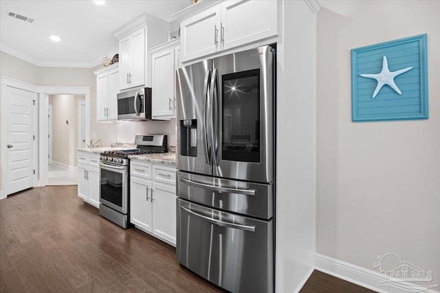 1504 Cadence Loop, Cantonment, FL 32533 - kitchen featuring appliances with stainless steel finishes, white cabinets, dark wood-type flooring, ornamental molding, and baseboards