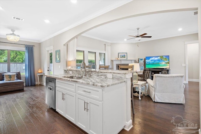 1504 Cadence Loop, Cantonment, FL 32533 - kitchen featuring open floor plan, a sink, dishwasher, arched walkways, and a fireplace