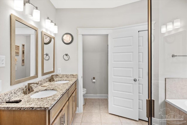 1504 Cadence Loop, Cantonment, FL 32533 - full bath with toilet, tile patterned floors, a tub to relax in, double vanity, and baseboards