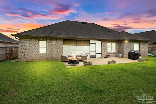 1504 Cadence Loop, Cantonment, FL 32533 - back of house at dusk featuring a fire pit, brick siding, a patio, and a shingled roof