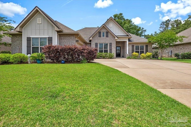 1504 Cadence Loop, Cantonment, FL 32533 - view of front of home with board and batten siding, a front yard, and brick siding