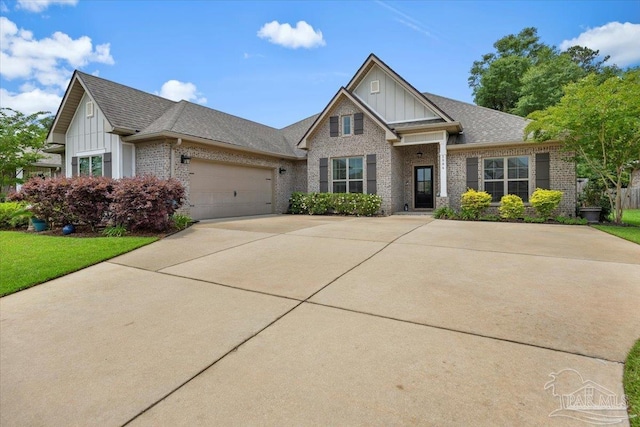 1504 Cadence Loop, Cantonment, FL 32533 - view of front facade with board and batten siding, brick siding, concrete driveway, an attached garage, and a shingled roof