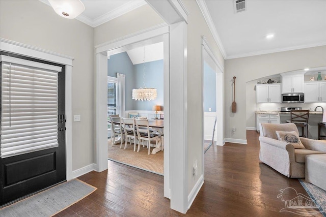 1504 Cadence Loop, Cantonment, FL 32533 - foyer entrance with a chandelier, dark wood-style flooring, baseboards, crown molding, and lofted ceiling