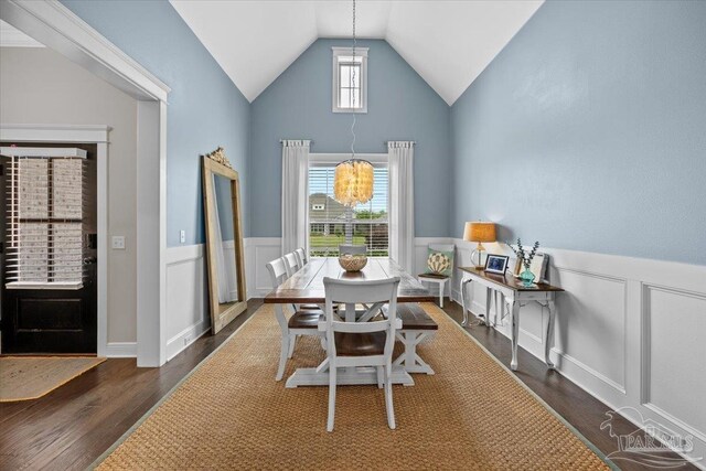 1504 Cadence Loop, Cantonment, FL 32533 - dining room featuring dark wood-type flooring, a wainscoted wall, a chandelier, high vaulted ceiling, and a decorative wall