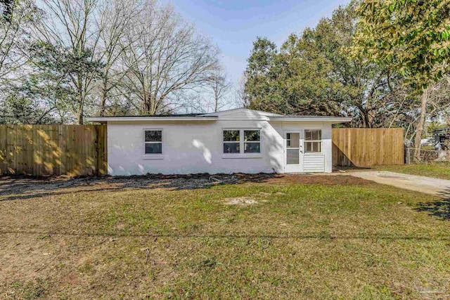 ranch-style house featuring fence and a front lawn