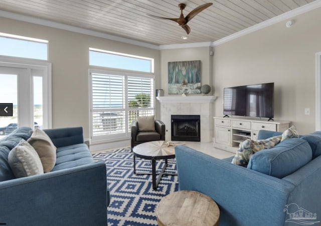 living room featuring ceiling fan, ornamental molding, a tile fireplace, and wooden ceiling