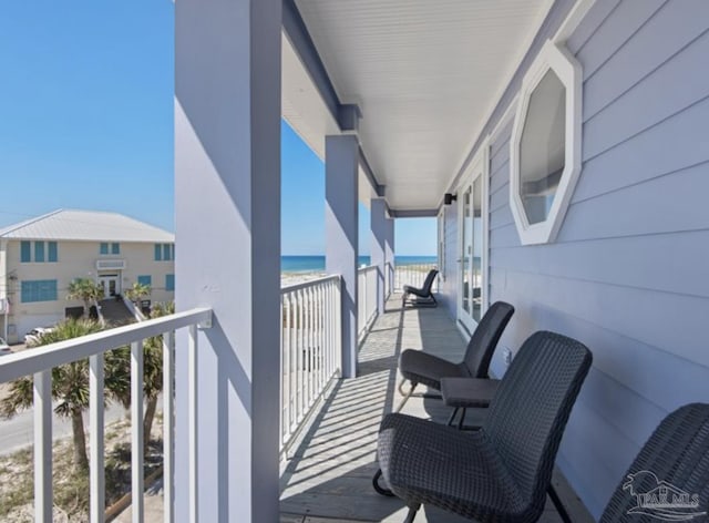 balcony with a water view and a beach view