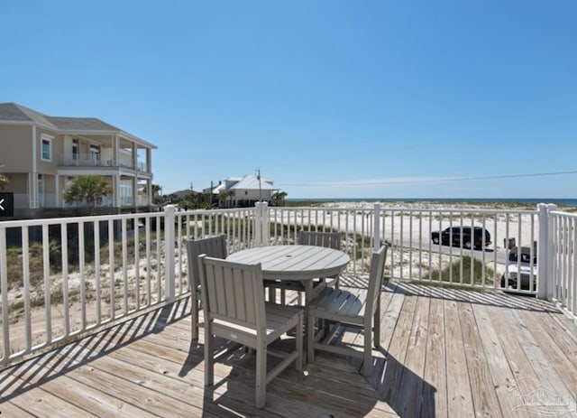 wooden deck featuring a water view and a view of the beach