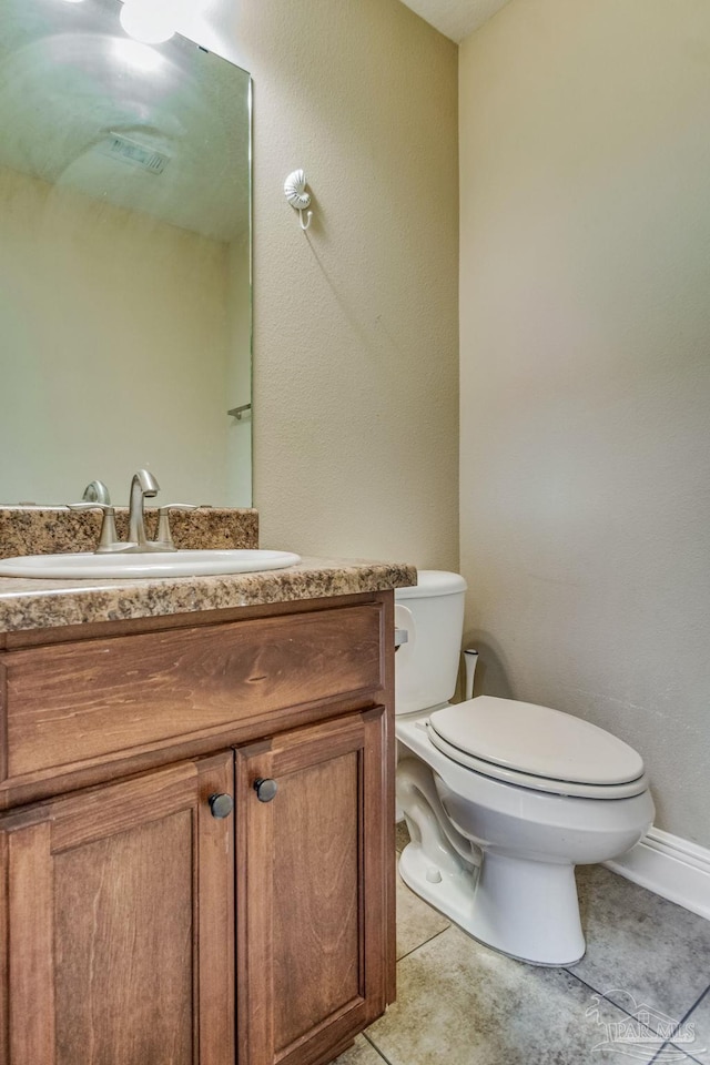 bathroom featuring tile patterned flooring, vanity, and toilet