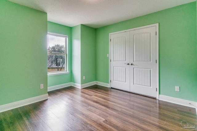 unfurnished bedroom featuring wood-type flooring and a closet