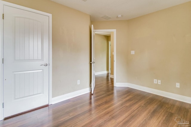 unfurnished bedroom with dark hardwood / wood-style floors