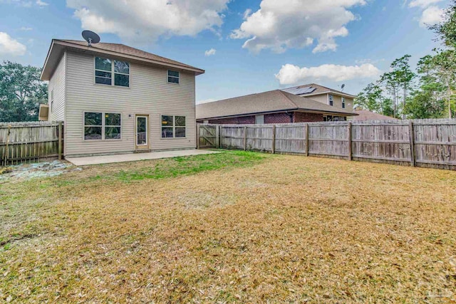 rear view of property featuring a patio area and a lawn