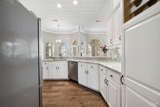 1328 Tour Dr, Gulf Breeze, FL 32563 - kitchen featuring appliances with stainless steel finishes, crown molding, white cabinets, light stone countertops, and a sink