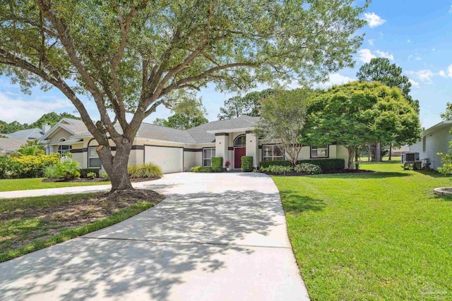 1328 Tour Dr, Gulf Breeze, FL 32563 - view of front of home with driveway, an attached garage, a front lawn, stucco siding, and central air condition unit
