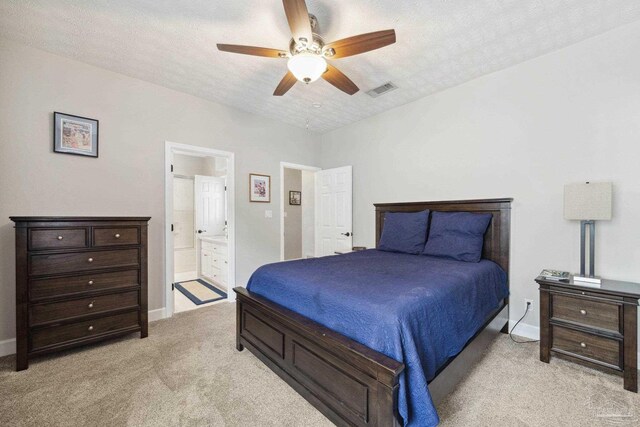 1328 Tour Dr, Gulf Breeze, FL 32563 - bedroom featuring light colored carpet, baseboards, connected bathroom, and a textured ceiling
