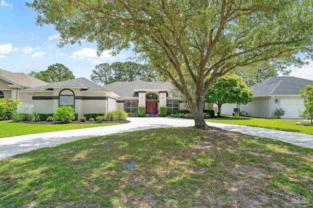 1328 Tour Dr, Gulf Breeze, FL 32563 - view of front facade with a front yard, stucco siding, and curved driveway