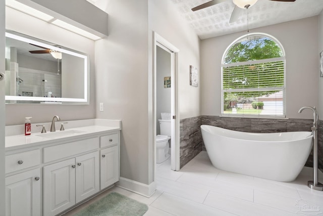 1328 Tour Dr, Gulf Breeze, FL 32563 - full bath featuring ceiling fan, plenty of natural light, vanity, tile walls, and a wainscoted wall