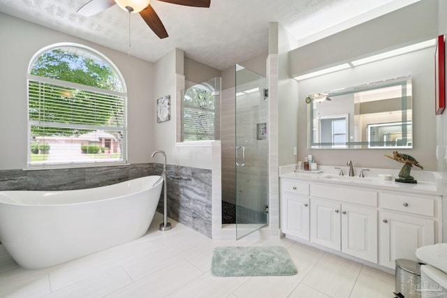 1328 Tour Dr, Gulf Breeze, FL 32563 - bathroom featuring ceiling fan, a freestanding tub, a stall shower, vanity, and tile patterned flooring