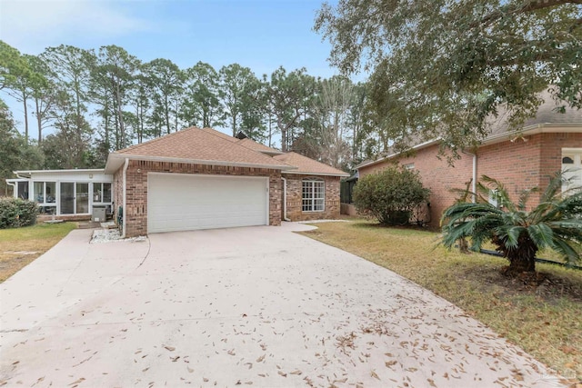 ranch-style home with a front lawn, a garage, and a sunroom