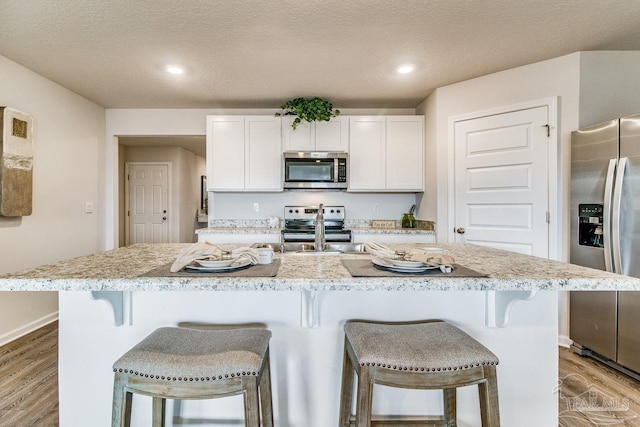 6340 Firefly Dr, Milton, FL 32583 - kitchen featuring a sink, light wood-style flooring, a breakfast bar, and stainless steel appliances