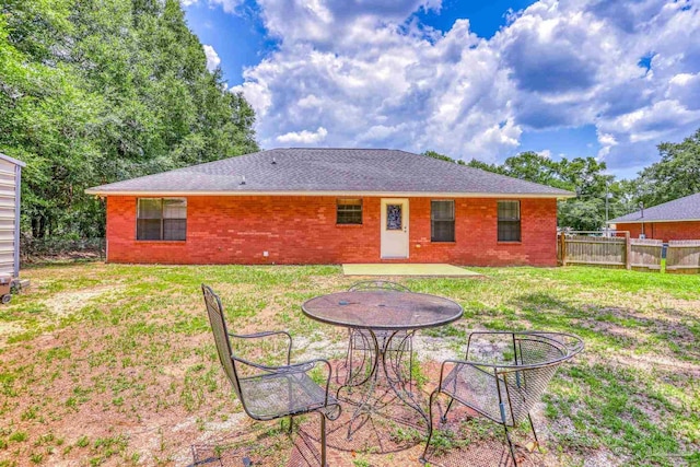 back of property featuring a lawn and a patio