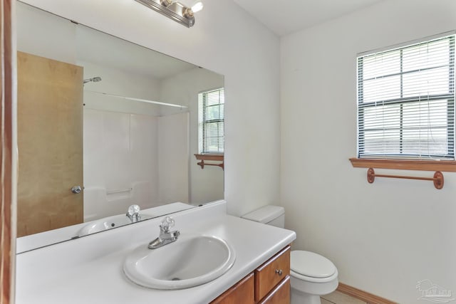 bathroom featuring vanity, toilet, and walk in shower