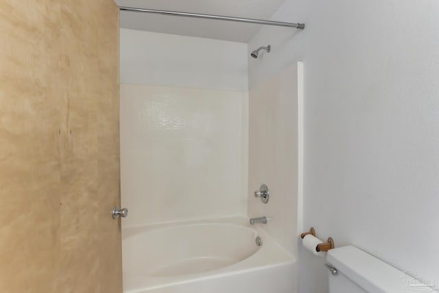 bathroom featuring bathtub / shower combination and toilet