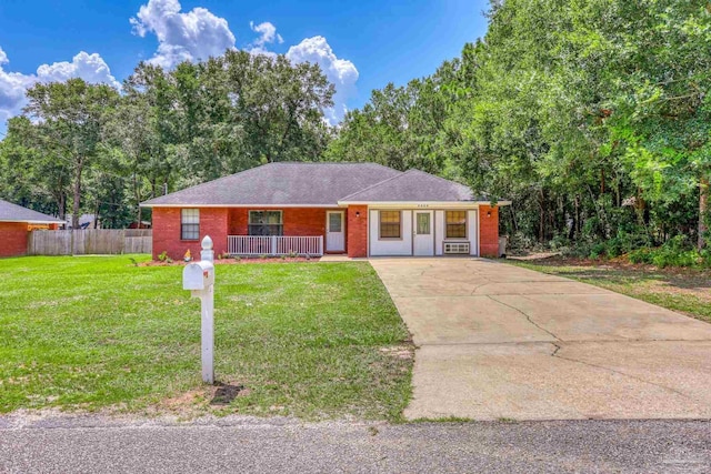 ranch-style home featuring cooling unit, covered porch, and a front yard