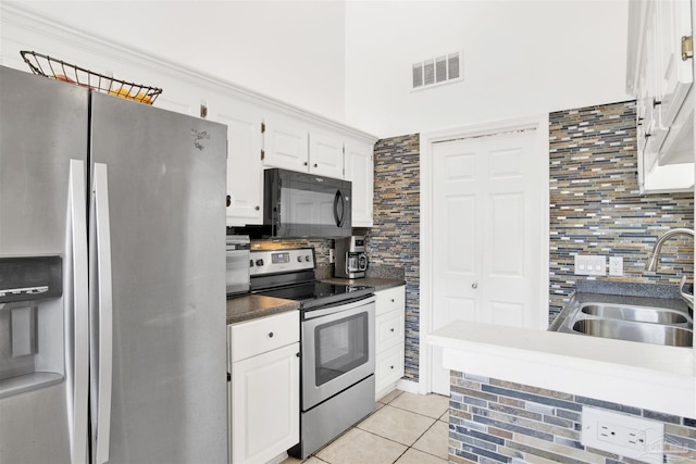 kitchen featuring white cabinets, sink, light tile patterned floors, tasteful backsplash, and stainless steel appliances