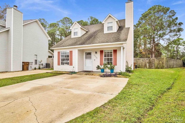 cape cod home featuring central AC and a front yard