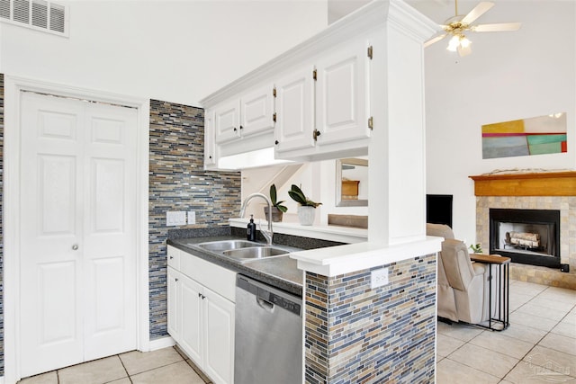 3228 Birdseye Cir, Gulf Breeze, FL 32563 - kitchen with stainless steel dishwasher, light tile patterned floors, a fireplace, white cabinetry, and dark countertops