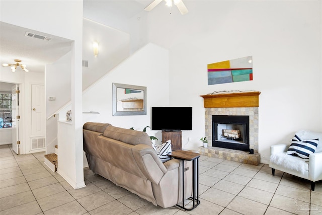 3228 Birdseye Cir, Gulf Breeze, FL 32563 - living area featuring stairway, light tile patterned flooring, a ceiling fan, a fireplace with raised hearth, and a high ceiling