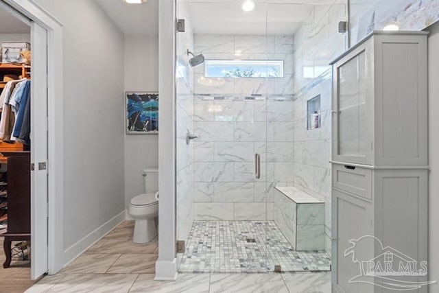 bathroom with a shower with door and toilet