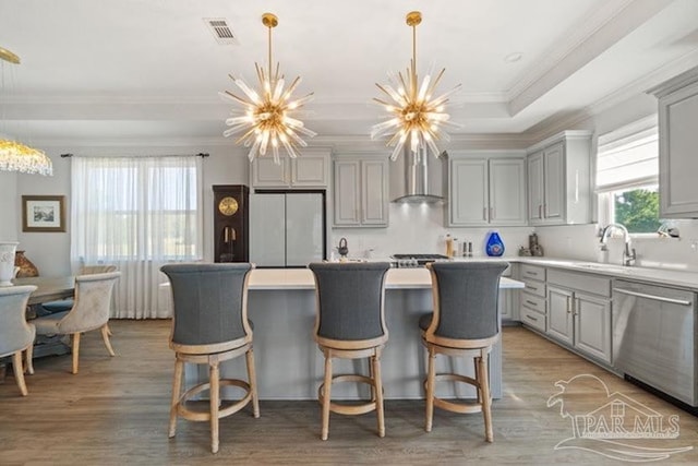 kitchen with gray cabinetry, wall chimney exhaust hood, stainless steel dishwasher, white fridge, and light wood-type flooring